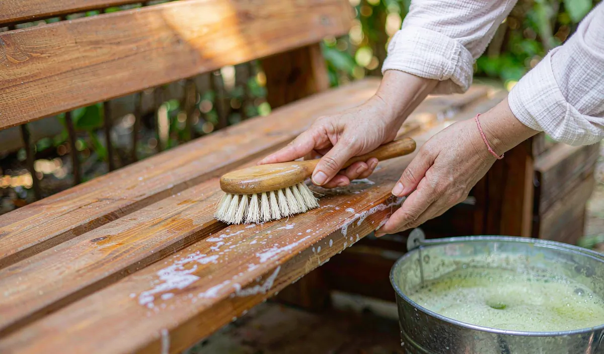 Scrubbing a slatted bench with a soft brush and a bucket of soapy water